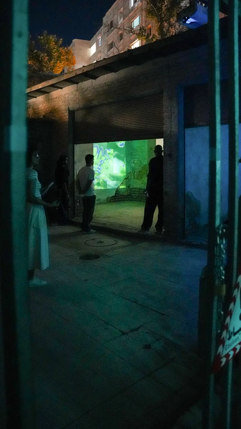 A visitor encounters projected moving images through a weathered doorway.