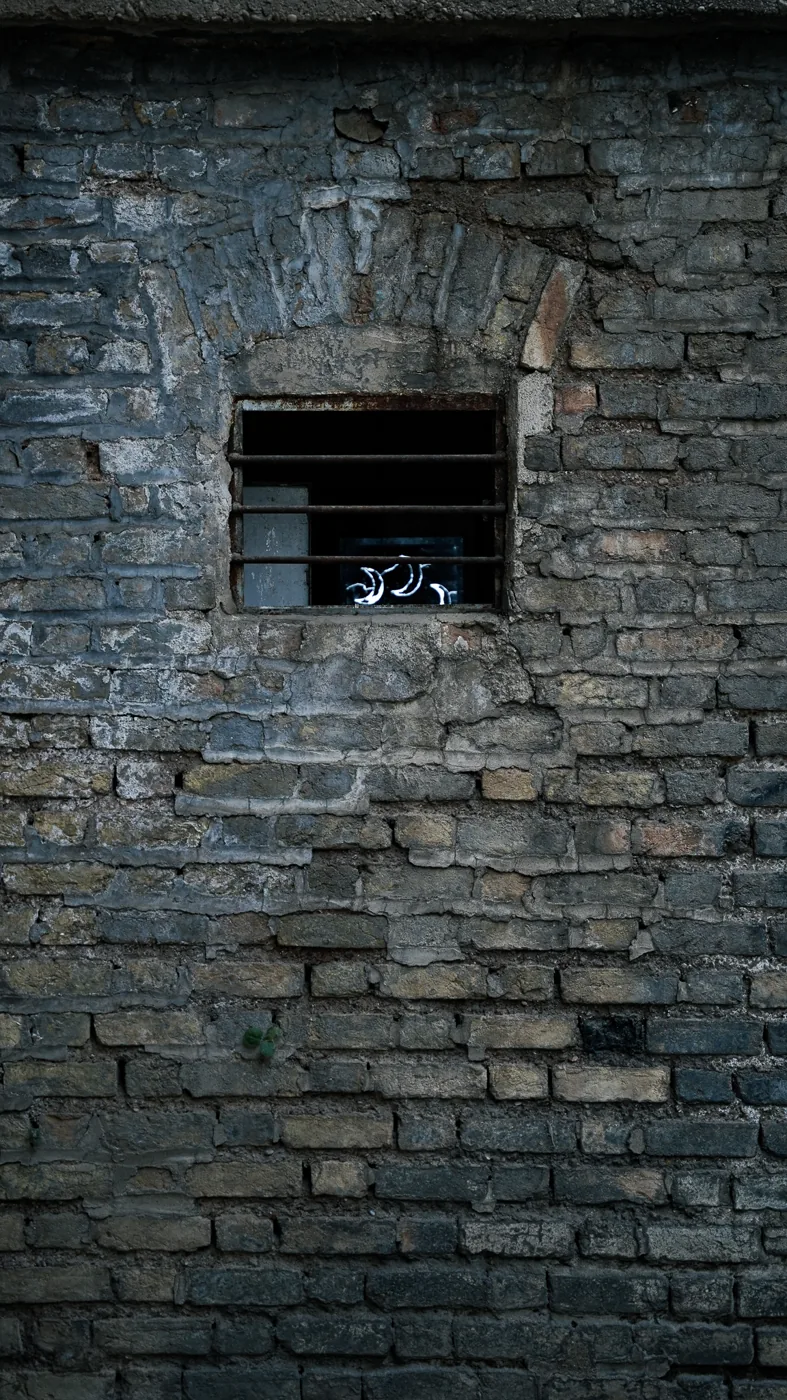 A small screen is embedded in the building’s exposed brick wall.