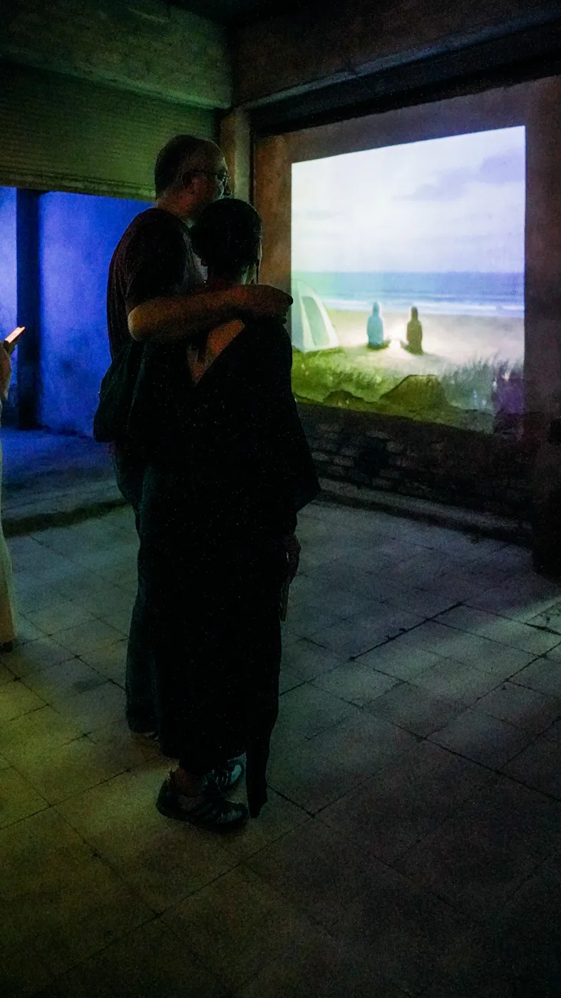 Visitors gather near a projection in the exhibition.