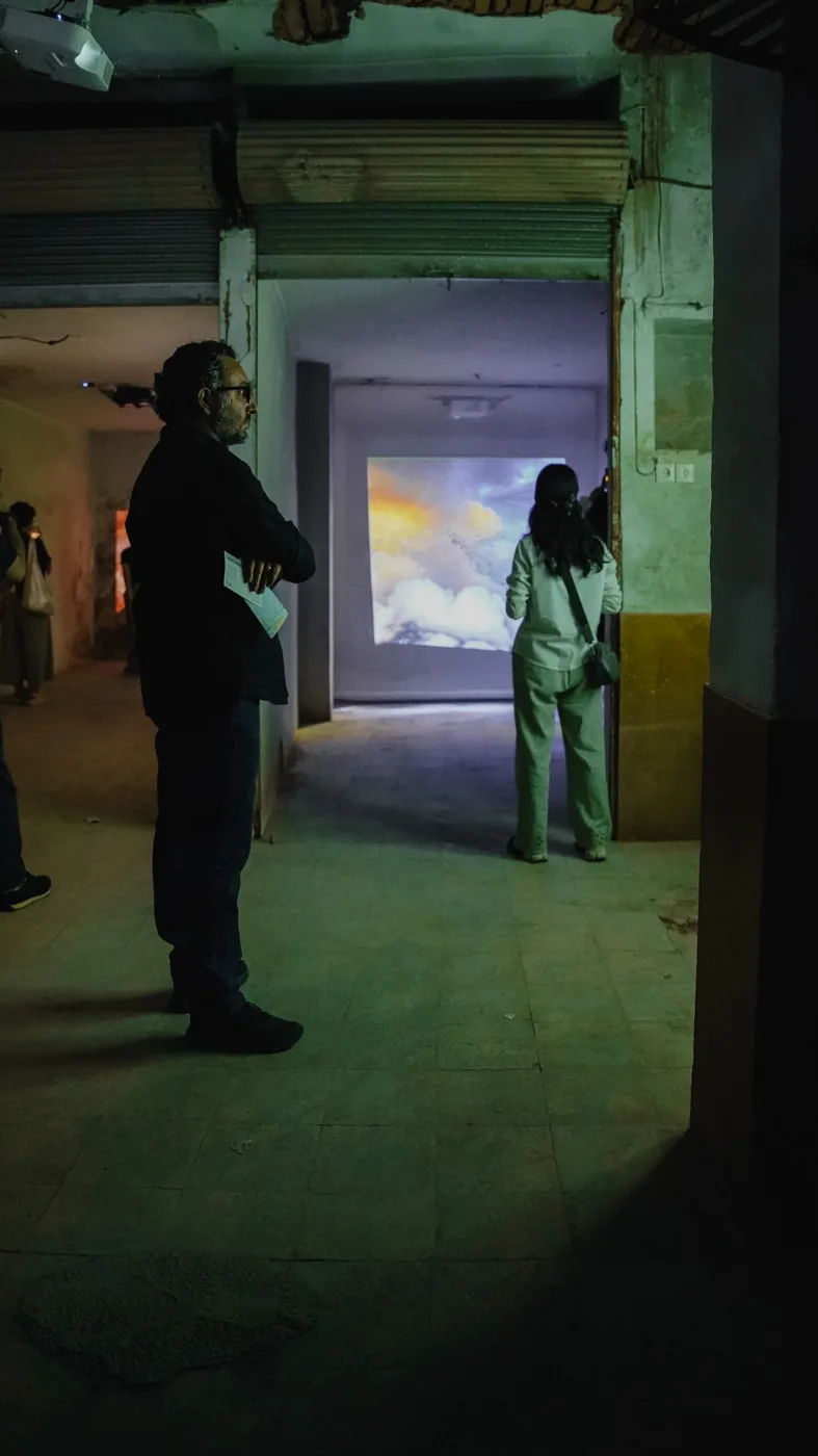 People move through a room lit by projected images.