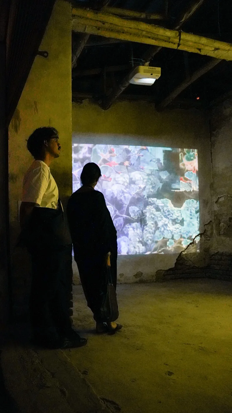 Two visitors share an encounter with a moving-image work.